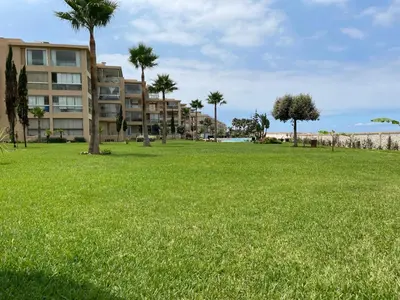 a park with palm trees and a building at Evasion bouznika in Sidi el Haj Bou Derbala