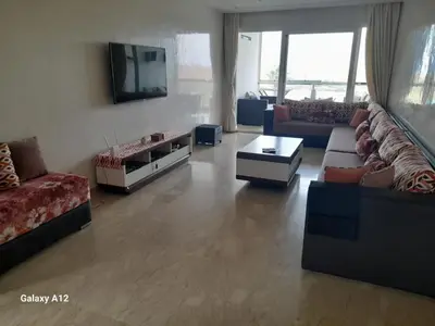 a living room with couches and a flat screen tv at Evasion bouznika in Sidi el Haj Bou Derbala