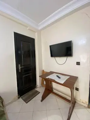 a room with a table and a television and a door at Appartement Neo in Oulad Hamida