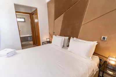 a bedroom with a large white bed and a bathroom at Casa Streets 3 BR Terrace - AppartAli Luxury Platform in Casablanca