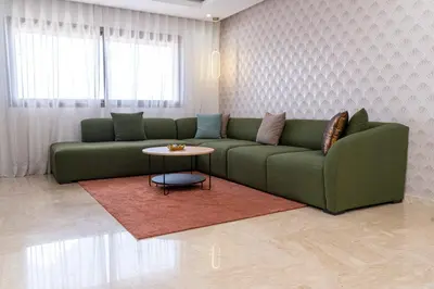 a living room with a green couch and a table at Casa Streets 3 BR Terrace - AppartAli Luxury Platform in Casablanca