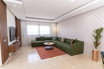 a living room with a green couch and a television at Casa Streets 3 BR Terrace - AppartAli Luxury Platform in Casablanca