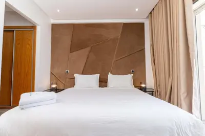 a bedroom with a large white bed with a large headboard at Casa Streets 3 BR Terrace - AppartAli Luxury Platform in Casablanca