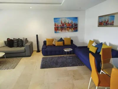 a living room with a blue couch and yellow pillows at Appartement de luxe Rabat Prestigia in Rabat