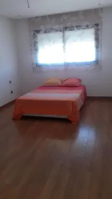 a bedroom with a bed with a window and a wooden floor at Appartement de luxe Rabat Prestigia in Rabat