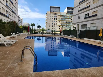 a swimming pool in the middle of two buildings at Appartement de luxe Rabat Prestigia in Rabat