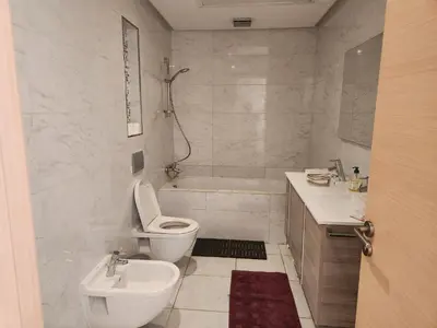 a white bathroom with a toilet and a sink at Appartement de luxe Rabat Prestigia in Rabat