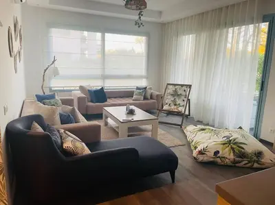 a living room with a couch and a table at Eden Island Bouznika Bel appartement avec jardin in Bouznika