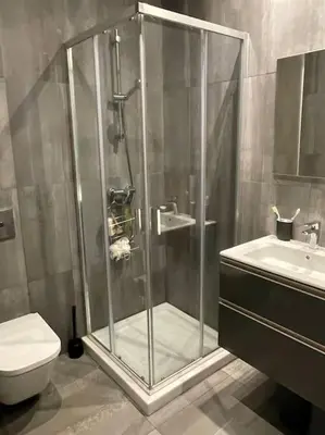 a shower in a bathroom with a toilet and a sink at Eden Island Bouznika Bel appartement avec jardin in Bouznika