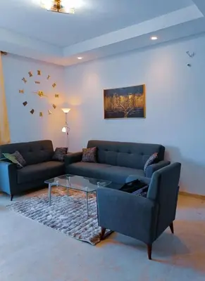 a living room with two couches and a clock on the wall at Zenitude in Casablanca