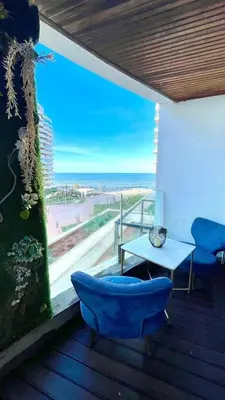 a balcony with a table and chairs and a view of the ocean at Luxueux Studio à La marina in LʼOasis