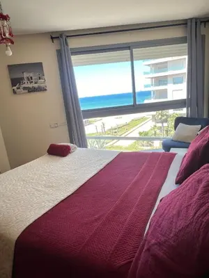 a bedroom with a bed with a view of the ocean at Luxueux Studio à La marina in LʼOasis
