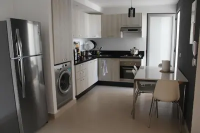 a kitchen with a stainless steel refrigerator and a table at Paradise 11 in Pont Blondin