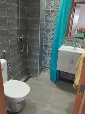 a bathroom with a toilet and a sink and a shower at appartement jinane in Bouznika