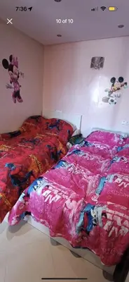 a bedroom with a bed with a pink comforter at الشقة دار بوعزة in Dar Bouazza