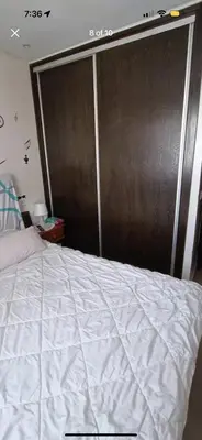 a bedroom with a large white bed and a brown wall at الشقة دار بوعزة in Dar Bouazza