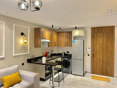 a kitchen with a refrigerator and a table in it at E19 Appt Moderne & Calme à Maarif ,Casablanca in Maarif