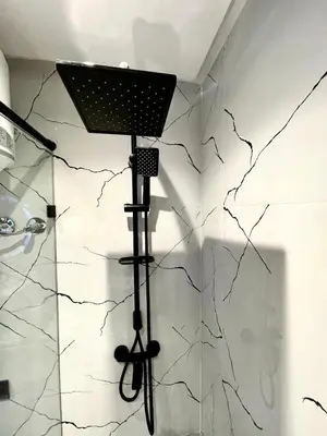 a shower with a light on the wall at E19 Appt Moderne & Calme à Maarif ,Casablanca in Maarif