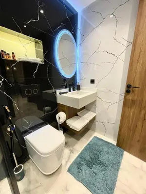 a bathroom with a white toilet and a mirror at E19 Appt Moderne & Calme à Maarif ,Casablanca in Maarif