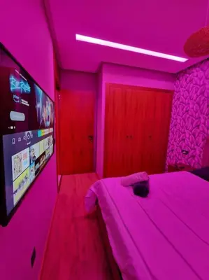 a bedroom with a pink room with a bed and a tv at luxury Studio with jacuzzi in Casablanca