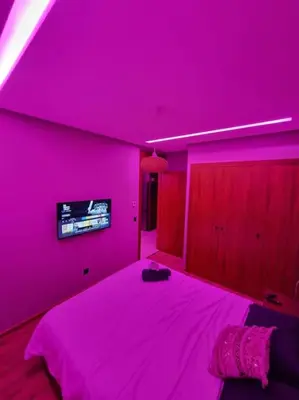 a pink room with a bed with a tv on the wall at luxury Studio with jacuzzi in Casablanca