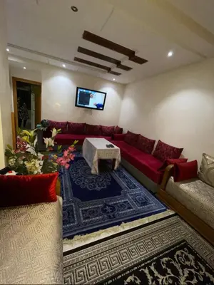a living room with a red couch and a table at Appartement vue sur mer in Casablanca