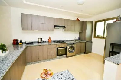 a kitchen with wooden cabinets and a stainless steel appliance at newly and fully furnished appartment in sidi rahal in Sidi Rahal