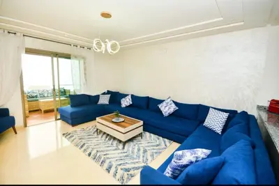 a living room with a blue couch and a table at newly and fully furnished appartment in sidi rahal in Sidi Rahal