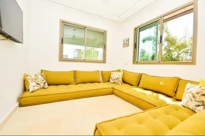 a large yellow couch in a living room with windows at newly and fully furnished appartment in sidi rahal in Sidi Rahal