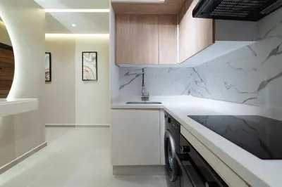 a kitchen with white marble countertops and a sink at Appartement Élégant et Spacieux in LʼOasis