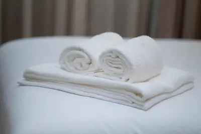 a pile of towels sitting on top of a bed at Appartement Élégant et Spacieux in LʼOasis