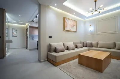 a living room with a couch and a coffee table at Appartement Élégant et Spacieux in LʼOasis