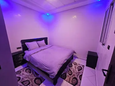 a bedroom with a purple room with a bed at Bel appartement à bouznika in Bouznika