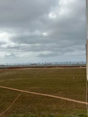 an empty field with the ocean in the background at appartement sublime in Oulad Hamida