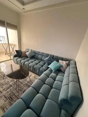 a living room with a blue couch and a table at appartement sublime in Oulad Hamida