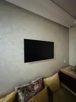 a living room with a couch and a flat screen tv at appartement sublime in Oulad Hamida