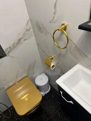 a bathroom with a gold toilet and a sink at Appartement Casablanca proche de la mer in Dar Mouddene