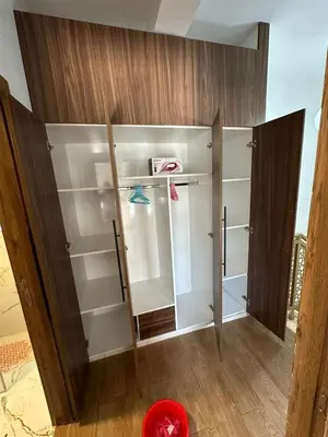 a closet with white shelves and a wooden door at Appartement Casablanca proche de la mer in Dar Mouddene