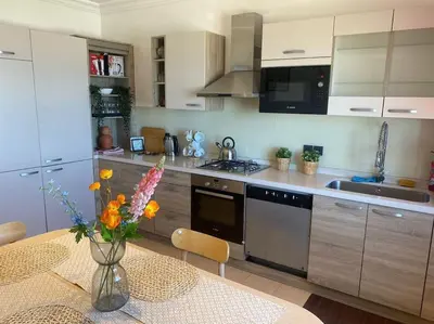 a kitchen with a table with a vase of flowers at Spacious Beachfront apartment in Casablanca