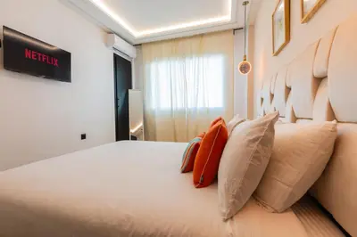 a bedroom with a large white bed with pillows at Appartement Moderne au Cœur de Rabat by MERAT HOME in Océan
