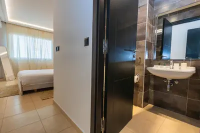 a bathroom with a sink and a mirror at Appartement Moderne au Cœur de Rabat by MERAT HOME in Océan