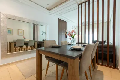 a dining room with a wooden table and chairs at Appartement Moderne au Cœur de Rabat by MERAT HOME in Océan