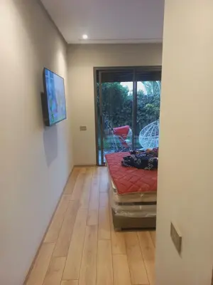 a room with a bed on a wooden floor at Résidence la vallée de Californie ahfad in Le Polo