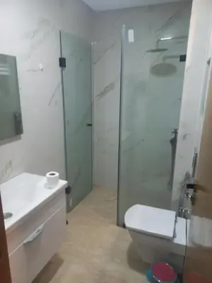 a bathroom with a shower and a toilet and a sink at Résidence la vallée de Californie ahfad in Le Polo