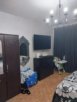 a bedroom with a bed and a flat screen tv at Assabah apartement in Kouas