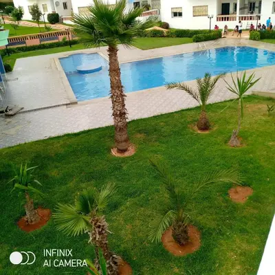 an overhead view of a swimming pool with palm trees at superbe appartement Al Mansouria-les jardins de l'Atlantique in Pont Blondin