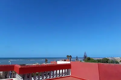 a red balcony with the ocean in the background at Superbe Villa Avec Piscine & Belle Vue Sur Mer in Tamaris