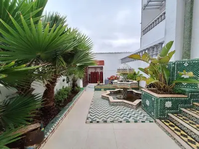 a courtyard with benches and palm trees in a building at Superbe Villa Avec Piscine & Belle Vue Sur Mer in Tamaris