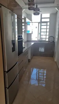 a kitchen with a stainless steel refrigerator in a room at Très bel Appartement avec Piscine et Jardin in Mansouria