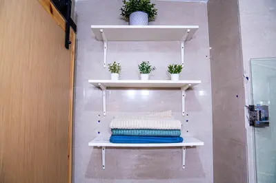 a shelf on a wall with towels and plants at Beautiful and Stylish 2BR Appartment with a wide Beach View in Mohammedia
